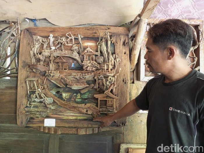 Sukito (41) warga Wonotingal, Srandakan, Bantul, saat mengerjakan karya 3D berbahan baku sampah kayu, Jumat (9/8/2024).