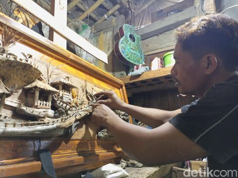 Sukito (41) warga Wonotingal, Srandakan, Bantul, saat mengerjakan karya 3D berbahan baku sampah kayu, Jumat (9/8/2024).