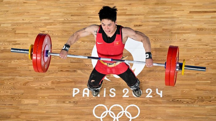 An overview shows Vietnams Trinh Van Vinh competing in the mens -61kg weightlifting event during the Paris 2024 Olympic Games at the South Paris Arena in Paris, on August 7, 2024. (Photo by Franois-Xavier MARIT / AFP)