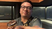 Adalagi momen ketika artis yang saat ini tinggal di Bali menikmati sebuah donat di kafe. Ia terlihat memegang donat dilapisi icing dan serpihan cokelat. Foto: Instagram @geofannytambunan