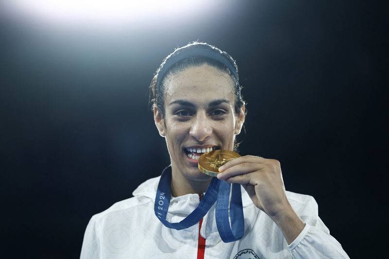 Imane Khelif Paris 2024 Olympics - Boxing - Women's 66kg - Victory Ceremony - Roland-Garros Stadium, Paris, France - August 09, 2024. Gold medallist Imane Khelif of Algeria bites her medal. REUTERS/Peter Cziborra