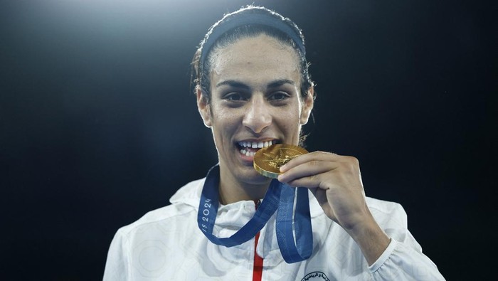 Paris 2024 Olympics - Boxing - Womens 66kg - Victory Ceremony - Roland-Garros Stadium, Paris, France - August 09, 2024. Gold medallist Imane Khelif of Algeria bites her medal. REUTERS/Peter Cziborra