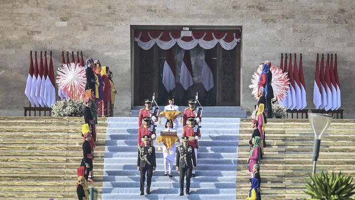 Tim Purna Paskibraka 2023 Kachina Ozora (tengah) membawa duplikat bendera Merah Putih berjalan menuju kendaraan taktis maung dalam acara kirab bendera Merah Putih dan naskah teks proklamasi menuju Ibu Kota Nusantara (IKN) di kawasan Monumen Nasional (Monas), Jakarta, Sabtu (10/8/2024). Kirab tersebut merupakan rangkaian persiapan peringatan HUT Ke-79 Kemerdekaan RI yang akan digelar di IKN, Penajam Paser Utara, Kalimantan Timur. ANTARA FOTO/Aprillio Akbar/nz