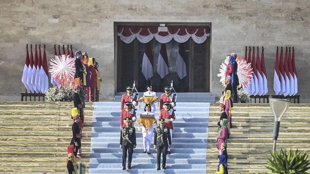Tim Purna Paskibraka 2023 Kachina Ozora (tengah) membawa duplikat bendera Merah Putih berjalan menuju kendaraan taktis maung dalam acara kirab bendera Merah Putih dan naskah teks proklamasi menuju Ibu Kota Nusantara (IKN) di kawasan Monumen Nasional (Monas), Jakarta, Sabtu (10/8/2024). Kirab tersebut merupakan rangkaian persiapan peringatan HUT Ke-79 Kemerdekaan RI yang akan digelar di IKN, Penajam Paser Utara, Kalimantan Timur. ANTARA FOTO/Aprillio Akbar/nz
