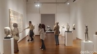 Pengunjung melihat patung yang dipamerkan.
