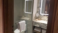 Kamar mandinya tampak mewah dengan menggunakan dinding dan wastafel marmer. Di dalamnya ada shower, wastafel, toilet, dan cermin. Foto: Almadinah Putri Brilian/deikcom