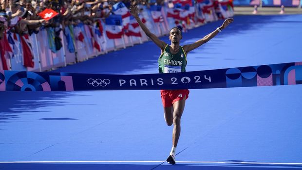 Ethiopia's Tamirat Tola celebrates after crossing the finish line to win the gold medal at the end of the men's marathon competition at the 2024 Summer Olympics, Saturday, Aug. 10, 2024, in Paris, France. (AP Photo/Vadim Ghirda)