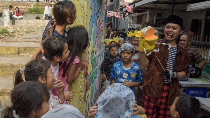 Teater boneka Taman Dorong Seniman dari kelompok teater Bon Puppet berinteraksi dengan anak-anak saat menampilkan teatrikal boneka bertajuk Taman Dorong di Braga, Bandung, Jawa Barat, Sabtu (10/8/2024). Teater tersebut ditampilkan dengan merespon ruang publik dan berkeliling dalam permukiman bersama anak-anak di Kawasan Braga agar tetap bisa berimajinasi, bertualang, bermain hingga peduli akan kondisi lingkungan perkampungan yang menjadi tempat tinggal dan berkehidupan. ANTARA FOTO/Novrian Arbi/YU