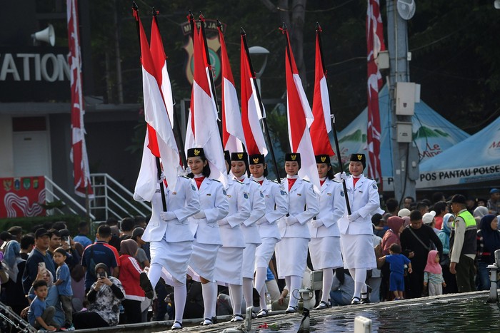 Sejumlah pasukan pengibar bendera (Paskibra) berbaris membawa bendera Merah Putih saat hari bebas kendaraan bermotor (HBKB) di Bundaran Hotel Indonesia (HI), Jakarta, Minggu (11/8/2024). Pengibaran bendera tersebut dilakukan selama Agustus sebagai bagian dari program Bulan Kebangsaan untuk menyambut HUT ke-79 Kemerdekaan Republik indonesia sekaligus meningkatkan kecintaan masyarakat terhadap Tanah Air. ANTARA FOTO/Aditya Pradana Putra/foc.
