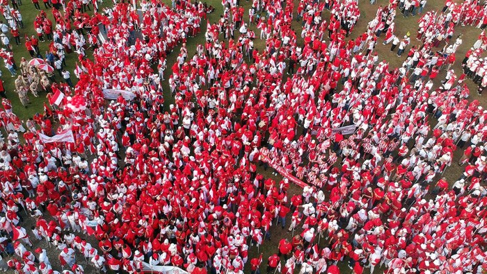 Foto udara sejumlah warga membawa bendera saat akan melaksanakan kirab bendera merah putih di Cibinong, Kabupaten Bogor, Jawa Barat, Minggu (11/8/2024). Pemerintah Kabupaten Bogor menyelenggarakan kirab bendera merah putih dengan 17.000 bendera dan diikuti 30.000 orang peserta, dalam rangka HUT Ke-79 Kemerdekaan RI. ANTARA FOTO/Yulius Satria Wijaya/foc.
