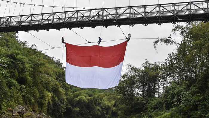 Melihat Gladi Bersih Upacara HUT RI di Jembatan Gantung Sungai Citanduy Foto udara warga RW 07 mengibarkan bendera merah putih pada gladi bersih upacara HUT ke-79 Kemerdekaan RI di Jembatan Gantung Sukamenak, Kampung Benteng, Kecamatan Purbaratu, Kota Tasikmalaya, Jawa Barat, Minggu (11/8/2024). Upacara yang diikuti warga lingkungan bantaran Sungai Citanduy itu, dilakukan dengan membentangkan bendera merah putih berukuran 60 meter persegi di Jembatan Gantung Sukamenak yang menghubungkan Kota Tasikmalaya dengan Kabupaten Ciamis. ANTARA FOTO/Adeng Bustomi/foc.