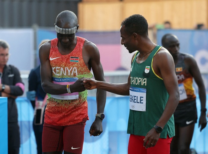 Paris 2024 Olympics - Athletics - Men's Marathon - Paris, France - August 10, 2024. Eliud Kipchoge of Kenya bumps fists with Kenenisa Bekele of Ethiopia before the race. REUTERS/Isabel Infantes