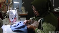 Seorang peserta menyelesaikan menjahit pakaian saat mengikuti pelatihan di PPKD Jakarta Selatan.