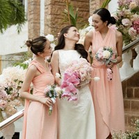 Cassandra tampil cantik dan simpel mengenakan gaun pengantin tanpa lengan berwarna putih. Rambutnya pun hanya diikat setengah dan dibuat bergelombang. Dalam foto tampak ia bersama kedua bridesmaidnya yang mengenakan dress berwarna peach. Foto: Instagram/@cassandraslee