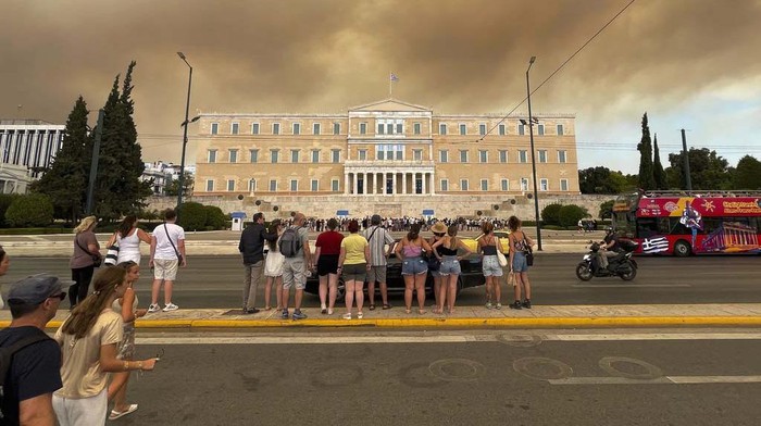 Smoke from wildfires is seen above the Greek parliament building in central Athens, Sunday, Aug. 11, 2024, after a blaze northeast of the capital forced evacuations in the area. (AP Photo/Derek Gatopoulos)