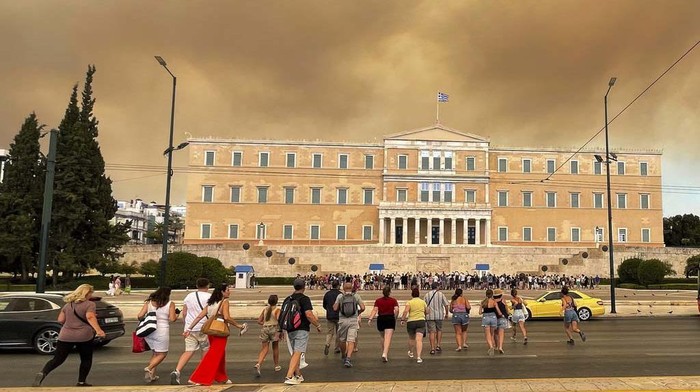 Smoke from wildfires is seen above the Greek parliament building in central Athens, Sunday, Aug. 11, 2024, after a blaze northeast of the capital forced evacuations in the area. (AP Photo/Derek Gatopoulos)