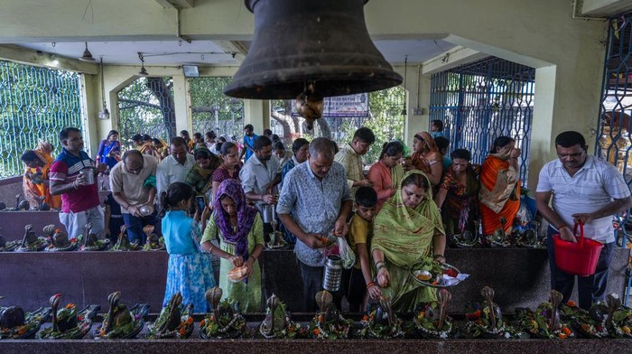 Devotees pour milk and water on the rows of Shiva Linga, the stone replica of Hindu god Shiva, as they offer prayer during 'Shravan Somwar', the last Monday of the Hindu calendar month Shravan, they consider auspicious in Kolkata, India, Monday, Aug. 12, 2024. (AP Photo/Bikas Das)
