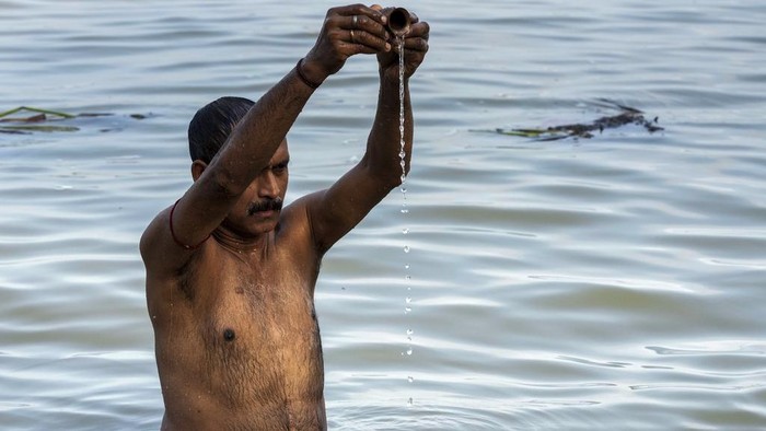 Devotees pour milk and water on the rows of Shiva Linga, the stone replica of Hindu god Shiva, as they offer prayer during 'Shravan Somwar', the last Monday of the Hindu calendar month Shravan, they consider auspicious in Kolkata, India, Monday, Aug. 12, 2024. (AP Photo/Bikas Das)