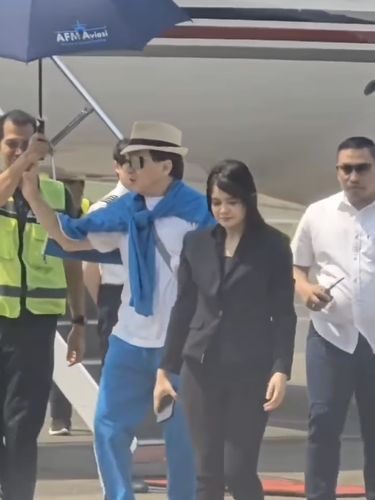 Jackie Chan dengan sopan menolak dipayungi saat tiba di Bandara Halim Perdana Kusuma.