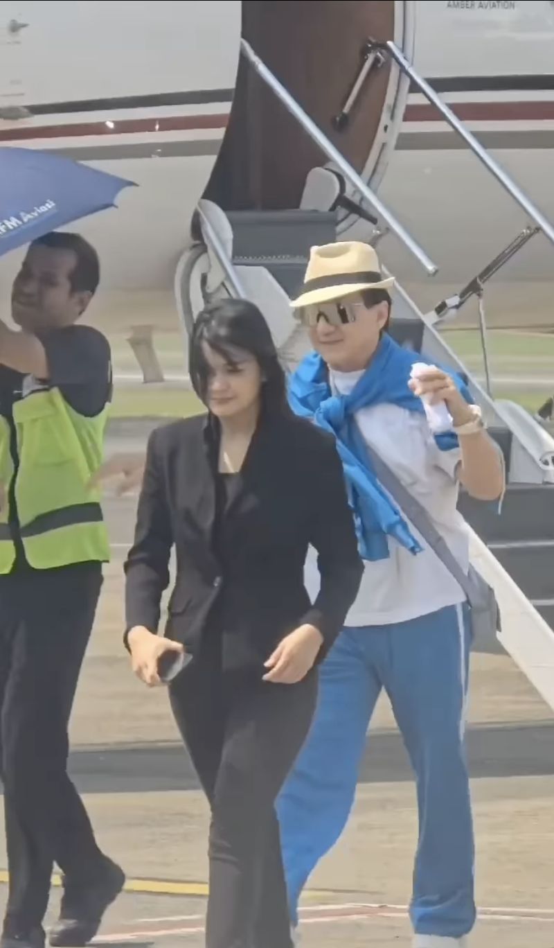 Jackie Chan dengan sopan menolak dipayungi saat tiba di Bandara Halim Perdana Kusuma.