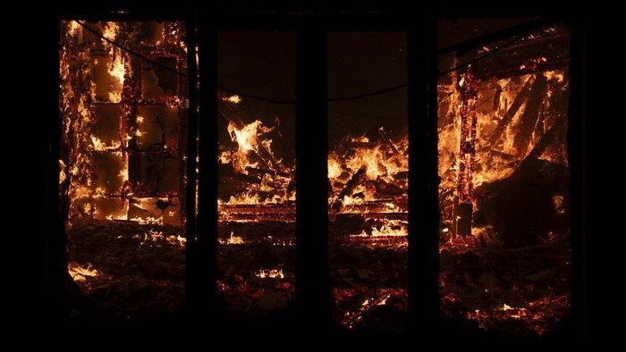 A house burns in Varnava village during a wildfire, north of Athens, Greece, Sunday, Aug. 11, 2024. Many regions of the country are on high alert due to high temperatures and winds. (AP Photo/Michael Varaklas)