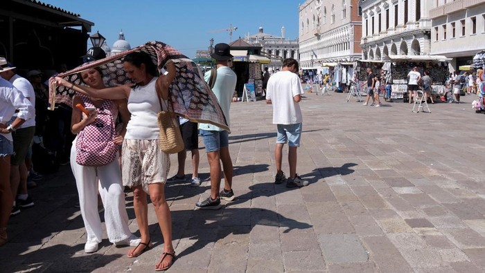 Saat Italia Hadapi Akhir Pekan Terpanas Tahun Ini Tourists walk during a heatwave as temperatures soar in Venice, Italy August 10, 2024. REUTERS/Manuel Silvestri