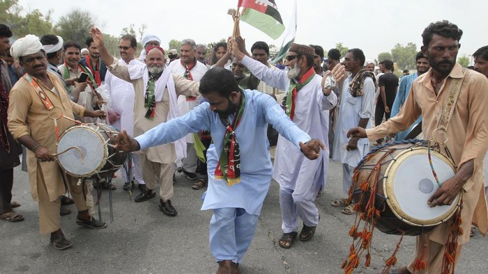 Sambutan Meriah Kepulangan Peraih Emas Olimpiade Pertama Pakistan Men's javelin gold medalist, Arshad Nadeem of Pakistan, centre, waves to people outside his village in Mian Channu, Khanewal district, of Pakistan, Sunday, Aug. 11, 2024. (AP Photo/Asim Tanveer)