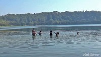 Beberapa anak-anak sedang mencari ikan saar debit air Ranu Pakis menyusut.