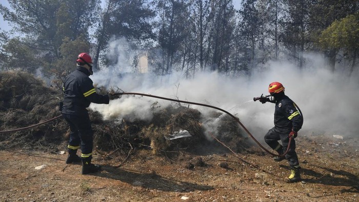 Kebakaran hutan di Yunani, Senin (12/8), menyebar dengan cepat ke pinggiran Athena akibat angin kencang. Petugas damkar berjibaku untuk padamkan api.