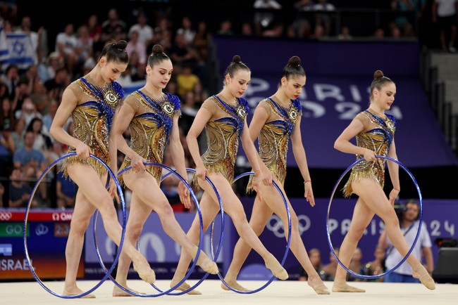 “Tim senam ritmik Israel mulai menjadi viral karena orang-orang menyadari makna dari kostum mereka,” demikian bunyi cuitan di X. “Itu adalah evil eye,” tulis netizen lagi. “Simbol mata di baju seragam tim senam Israel mirip lambang Illuminati,” tulis netizen lainnya. Foto: Getty Images/Jamie Squire