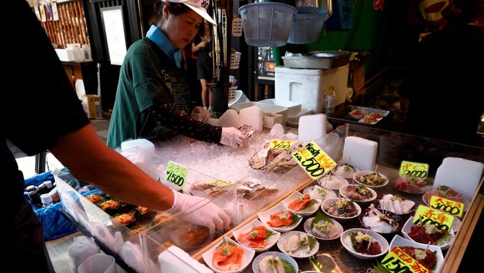 Vendors prepare seafood for sale at Tsukiji Outer Market in Tokyo, Japan, August 12, 2024. REUTERS/Willy Kurniawan