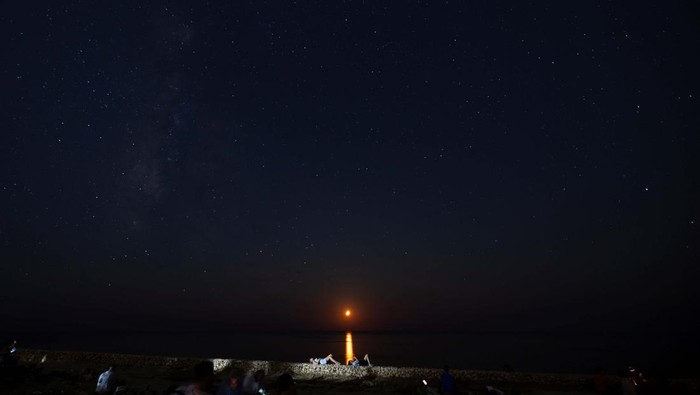Hujan Meteor Perseid Jadi Tontonan Warga Malta People look out for shooting stars as the moon sets during the annual Perseid meteor shower at Migra l-Ferha, outside the town of Rabat, Malta August 12, 2024. REUTERS/Darrin Zammit Lupi