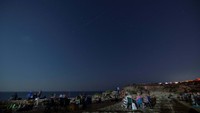 Warga menyaksikan hujan meteor Perseid di langit Migra l-Ferha, di luar kota Rabat, Malta, 12 Agustus 2024.  