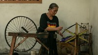 Perajin menyelesaikan pembuatan tenun lurik menggunakan alat tenun bukan mesin di Kurnia Lurik, Krapyak, Panggungharjo, Sewon, Bantul, DI Yogyakarta, Selasa (13/8/2024).