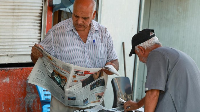 Nasib Penjual Koran Irak di Tengah Gempuran Digitalisasi A man reads and sells newspapers on a street in Baghdad, Iraq, August 5, 2024. Newspapers are now obsolete in Iraq, as people commonly use mobile devices to read the news. REUTERS/Ahmed Saad