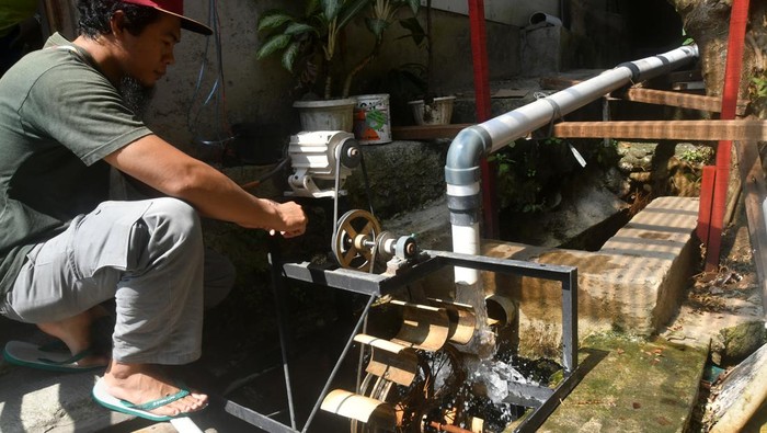 Penampakan PLTA dari Barang Bekas di Bogor, Pasok Listrik buat Fasilitas Umum Warga menunjukkan cara kerja kincir air menjadi energi listrik di Perumahan Pabaton Indah RW 07, Kota Bogor, Jawa Barat, Selasa (13/8/2024). Pembangkit Listrik Tenaga Air (PLTA) yang dibuat dari barang bekas di selokan air perumahan tersebut dimanfaatkan untuk penerangan fasilitas umum seperti pos satpam, tempat maggot, dan balai RW serta telah mendapatkan penghargaan dari Kementerian Lingkungan Hidup dan Kehutanan dengan predikat utama sebagai Kampung Iklim tahun 2024. ANTARA FOTO/Arif Firmansyah/tom.