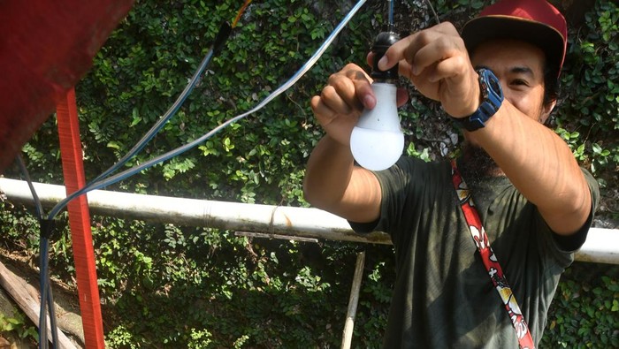Penampakan PLTA dari Barang Bekas di Bogor, Pasok Listrik buat Fasilitas Umum Warga menunjukkan cara kerja kincir air menjadi energi listrik di Perumahan Pabaton Indah RW 07, Kota Bogor, Jawa Barat, Selasa (13/8/2024). Pembangkit Listrik Tenaga Air (PLTA) yang dibuat dari barang bekas di selokan air perumahan tersebut dimanfaatkan untuk penerangan fasilitas umum seperti pos satpam, tempat maggot, dan balai RW serta telah mendapatkan penghargaan dari Kementerian Lingkungan Hidup dan Kehutanan dengan predikat utama sebagai Kampung Iklim tahun 2024. ANTARA FOTO/Arif Firmansyah/tom.