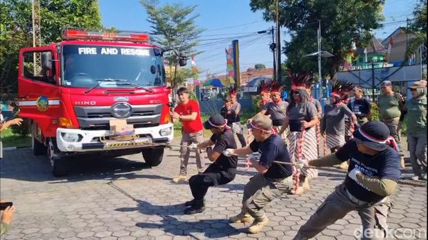Sejumlah anggota Satpol PP Banyumas mengikuti kegiatan tarik truk damkar dalam rangka memperingati HUT RI ke-79 di halaman kantornya, Selasa (13/8/2024).