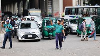 Polisi memberi isyarat di persimpangan Shahbagh untuk mengatur lalu lintas, di Dhaka, Bangladesh, Senin (12/8/2024).  