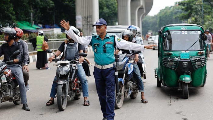 A policeman gestures to vehicles at Shahbagh intersection to control traffic as Bangladeshi police return on duty, following the resignation of former Prime Minister Sheikh Hasina, in Dhaka, Bangladesh, August 12, 2024. REUTERS/Mohammad Ponir Hossain