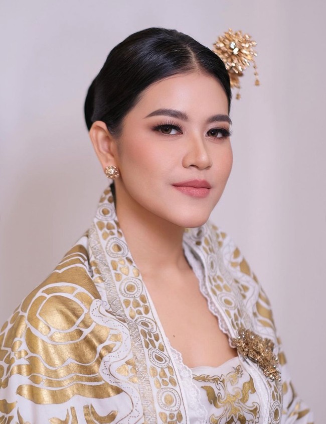 Tampil anggun, Kahiyang tampak memilih untuk menyanggul rambutnya. Ia juga tampak menambahkan hiasan berupa tusuk konde yang juga berwarna gold. Untuk aksesorinya tampak simpel dengan sepasang anting tusuk berbentuk bunga. Foto: Instagram/@malvava/@ayanggkahiyang