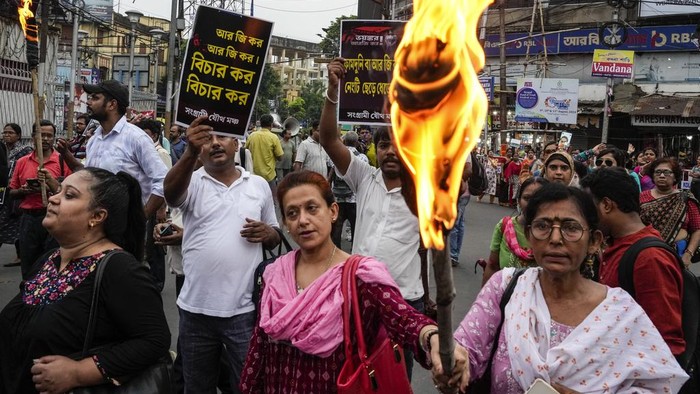 Following a murder of a 31 year old post-graduate trainee (PGT) doctor by rape and torture inside a government hospital, activists of different humanitarian and political organisations and medical professionals participate in a rally with posters and torches demanding adequate intervention of the ruling government and exemplary punishment of the culprits, in Kolkata, India, Tuesday, Aug. 13, 2024. Banner in Bangla reads, Civil society march of shame. (AP Photo/Bikas Das)