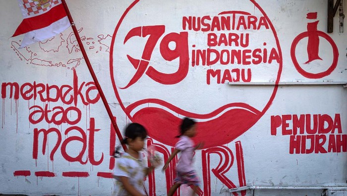 Seorang warga bersantai dengan katar belakang mural bertema kemerdekaan di Kelurahan Purwosari, Semarang, Jawa Tengah, Rabu (14/8/2024). Warga dari sejumlah perkampungan di Kota Semarang menghiasi lingkungan mereka dengan berbagai macam seni dekorasi seperti tulisan mural bertema kemerdekaan sebagai wujud rasa cinta terhadap perjuangan para pahlawan dalam merebut kemerdekaan sekaligus untuk memeriahkan HUT ke-79 Republik Indonesia. ANTARA FOTO/Aji Styawan/nym.