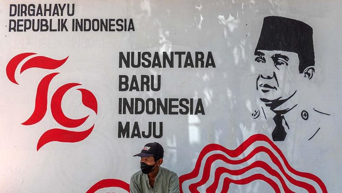Seorang warga bersantai dengan katar belakang mural bertema kemerdekaan di Kelurahan Purwosari, Semarang, Jawa Tengah, Rabu (14/8/2024). Warga dari sejumlah perkampungan di Kota Semarang menghiasi lingkungan mereka dengan berbagai macam seni dekorasi seperti tulisan mural bertema kemerdekaan sebagai wujud rasa cinta terhadap perjuangan para pahlawan dalam merebut kemerdekaan sekaligus untuk memeriahkan HUT ke-79 Republik Indonesia. ANTARA FOTO/Aji Styawan/nym.