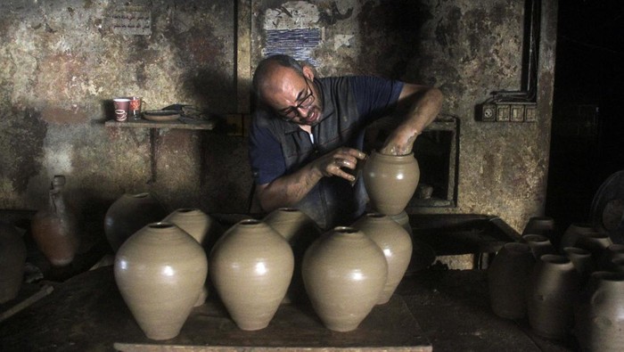 A person works in a pottery workshop as Palestinians respond to an increase in the demand for clay pots used to cool water due to power cuts and hot weather, according to workers, amid the Israel-Hamas conflict, in Gaza City August 13, 2024. REUTERS/Mahmoud Issa