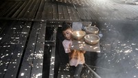 Seorang anak laki-laki membawa pot saat bekerja di sebuah pabrik tembikar di Kota Gaza, Senin (13/8/2024).