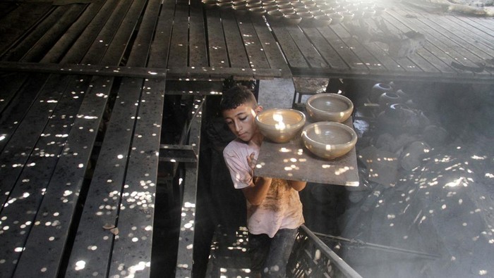 Permintaan Tembikar Meningkat di Tengah Serangan Israel ke Gaza A person works in a pottery workshop as Palestinians respond to an increase in the demand for clay pots used to cool water due to power cuts and hot weather, according to workers, amid the Israel-Hamas conflict, in Gaza City August 13, 2024. REUTERS/Mahmoud Issa