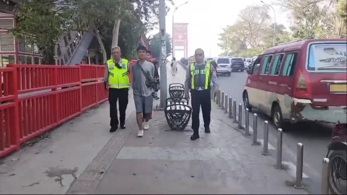Polisi saat mengamankan pelaku pencurian di Jembatan Ampera.
