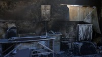 Kebakaran mereda berkat angin yang mulai melemah, menghentikan laju kebakaran yang telah menewaskan satu orang dan membakar mobil, bangunan, ladang, dan hutan. REUTERS/Stelios Misinas