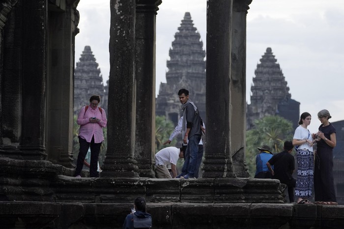 Tourists visit the Angkor Wat temple in Siem Reap province, Cambodia, Friday, Aug. 2, 2024. A centuries-old Angkor temple complex that sprawls across some 400 square kilometers (155 square miles), containing the ruins of capitals of various Cambodian empires from the 9th to the 15th century is the countrys most popular tourist attraction and in the first half of this year attracted more than half a million international tourists. (AP Photo/Heng Sinith)